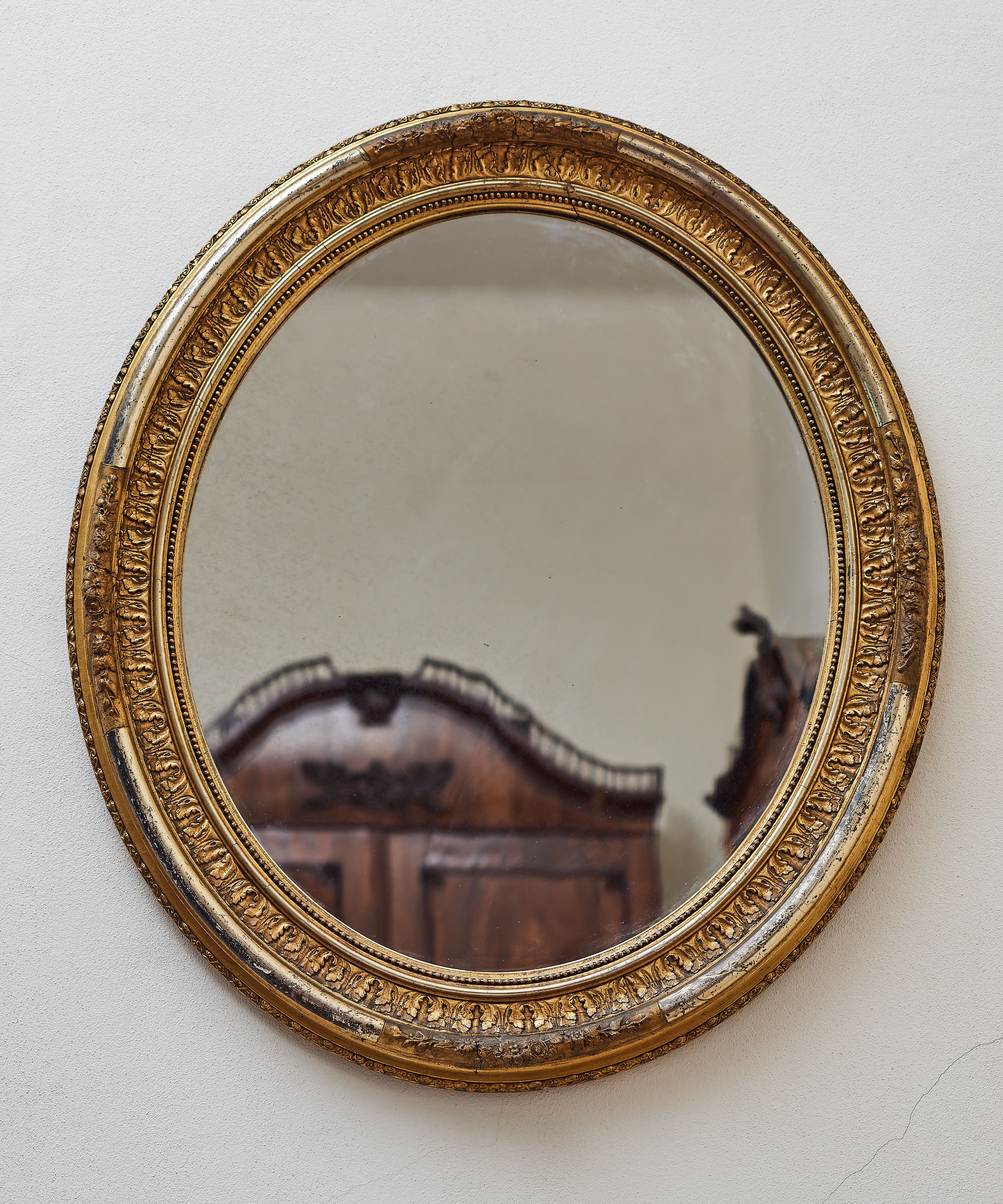 Oválné zlacené zrcadlo s bohatě zdobeným rámem, 19. století